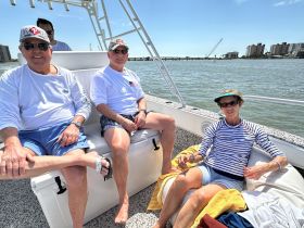 A group of friends enjoys a relaxing day on the boat, soaking up the sun and taking in the scenic waterfront views.