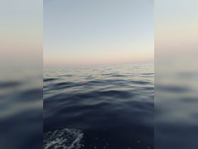 An unclear image of the ocean surface at dusk, lacking identifiable subjects or details.