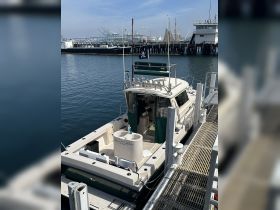 A view of a yacht docked at the marina, showcasing its sleek design and amenities. Ideal for fishing trips or leisurely cruises.