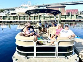A joyful family gathers on a pontoon boat, enjoying a sunny day on the water — perfect for creating lasting memories together.