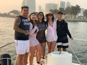 A joyful group of friends poses together on a boat, capturing a memorable moment on the water — perfect for celebrations and outings.