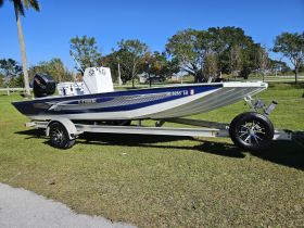 A sleek Lowe boat displayed on a trailer, showcasing its design and features in a sunny outdoor setting.
