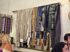 An interior shot featuring various leather strips displayed on a wall, with people partially visible in the background, creating an unclear focus.