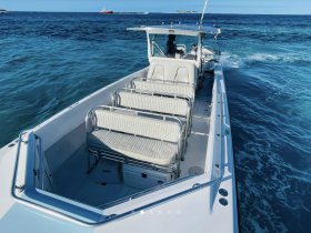 Interior view of a spacious boat featuring comfortable seating and a helm, ideal for group outings on the water.
