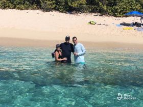 A joyful group enjoys a sunny day at the beach, wading in crystal-clear waters — perfect for memorable celebrations and fun in the sun.