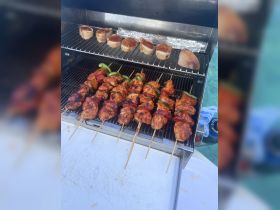 Delicious skewers of grilled chicken and bread are prepared on the barbecue, perfect for a day of fun on the water.