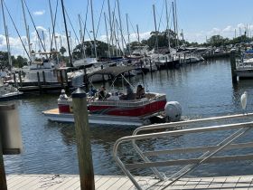 A lively group enjoys a day on a pontoon boat at the marina, surrounded by other vessels — perfect for family outings or group adventures on the water.