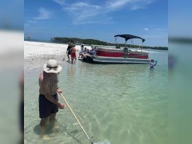 A fun day at the beach with a group enjoying a pontoon boat, swimming, and exploring the shallow waters — perfect for family outings and summer adventures.