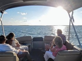 A group enjoys a scenic boat ride at sunset, capturing the essence of relaxation and camaraderie on the water.