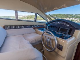 A well-equipped helm area inside a luxurious boat, featuring a comfortable seating area and advanced navigation controls, perfect for a smooth sailing experience.