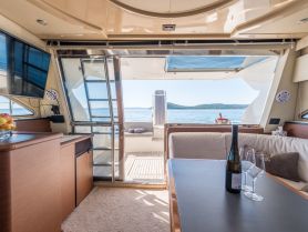 A beautifully designed interior of a yacht showcasing a cozy seating area with a view of the serene waters, perfect for relaxation and enjoying the journey.