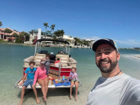 A joyful family enjoys a day on a pontoon boat at the beach, capturing fun moments in the sun — perfect for family outings and beach adventures.