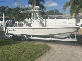 A pristine Everglades boat is showcased, parked on a trailer with a clear view of its sleek design and features, perfect for fishing or leisure outings.