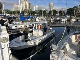 A group of individuals prepares to board a boat at the marina, showcasing the vibrant atmosphere of boating activities in the city.