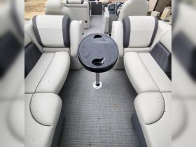 Interior view of a Sylvan boat showcasing comfortable seating and a central table, perfect for relaxing and socializing on the water.