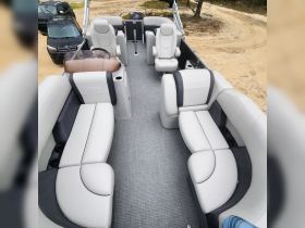 Interior view of a Sylvan pontoon boat showcasing spacious seating and a helm area, perfect for comfortable outings on the water.