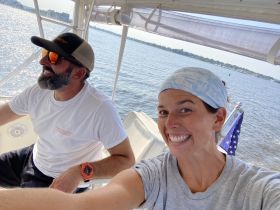 A joyful moment captured on a boat with two individuals enjoying their time on the water, showcasing the fun and camaraderie of boating adventures.