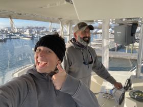 A joyful moment aboard a boat with two people smiling and enjoying their time at the marina, showcasing the excitement of boating adventures.