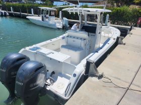 A center console boat docked at the marina, featuring twin Yamaha engines and a spacious layout, perfect for fishing or day cruising.