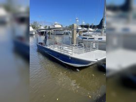 A pontoon boat docked at a marina, showcasing its spacious design and inviting atmosphere for leisurely outings on the water.