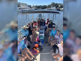 A lively group enjoys a day on the water aboard a boat, complete with snacks and drinks, perfect for family outings and fun adventures.