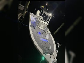 A sleek speedboat docked at night, illuminated by ambient lighting, showcasing its modern design and features.
