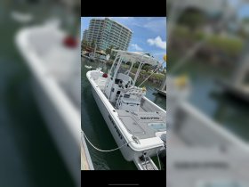 A sleek Sea Pro center console boat docked at the marina, showcasing its modern design and spacious layout, perfect for fishing or day cruising.