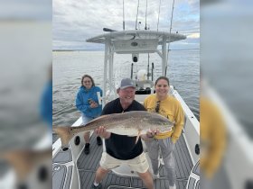 A joyful group celebrates a successful fishing trip aboard a boat, showcasing their impressive catch. Perfect for fishing enthusiasts and adventure seekers.