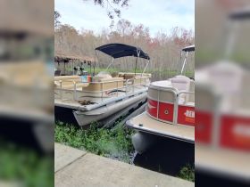 Two pontoon boats docked in a serene setting, surrounded by lush greenery — perfect for leisurely outings on the water.