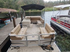 Interior view of a pontoon boat featuring spacious seating, ideal for relaxing on the water. Perfect for family outings or group gatherings.