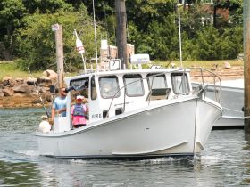 A father and daughter enjoy a fishing trip aboard their boat, showcasing a perfect day on the water together.