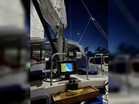 A cozy view of the helm inside a sailing catamaran at night, showcasing navigation equipment and comfortable seating — perfect for nighttime sailing adventures.