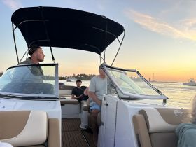 A group of friends enjoys a relaxing evening on a boat at sunset, capturing the essence of a perfect day on the water.