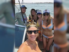 A lively group of friends celebrates on a boat with champagne, capturing the essence of a fun-filled day on the water.