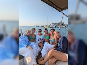 A group of friends enjoys a sunny day on the boat, showcasing the perfect setting for summer celebrations and memorable outings on the water.