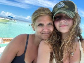 A mother and daughter share a joyful moment by the water, capturing the essence of family fun and relaxation during their beach day.