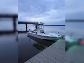 A sleek speedboat is docked at twilight, showcasing its design against a serene water backdrop — perfect for fishing or leisure outings.