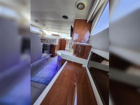 A spacious interior view of a luxurious boat cabin, featuring elegant seating and modern amenities, perfect for comfortable cruising.