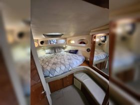 Cozy interior cabin of a boat featuring a comfortable bed and seating area, perfect for relaxing during overnight trips on the water.