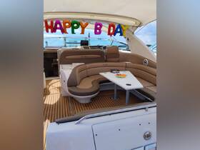 The interior of a luxurious boat is decorated with colorful balloons for a birthday celebration, featuring comfortable seating and a dining area perfect for gatherings.
