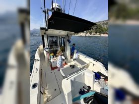 A cozy interior view of a fishing boat featuring children engaged in activities, showcasing the helm and seating area — perfect for family fishing trips.