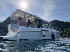 A lively group enjoys their time aboard a Merry Fisher boat, creating memorable moments against a stunning natural backdrop.