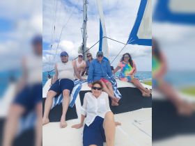 A cheerful group enjoys a sailing adventure on a catamaran, soaking up the sun and creating lasting memories on the water.