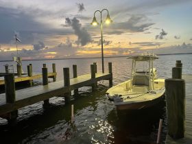 A serene view of a speedboat docked at sunset, highlighting the tranquil waters and picturesque sky — perfect for evening cruises.
