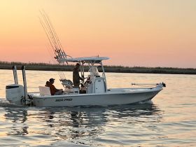 A group enjoys a fishing trip on a Sea Pro boat during a stunning sunset, showcasing the perfect blend of adventure and relaxation on the water.
