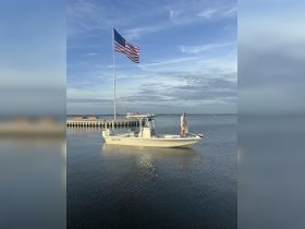 A fisherman prepares his gear aboard a Sea Pro boat, with an American flag waving in the background — a perfect scene for a day of fishing on the water.