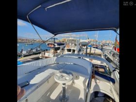 A well-appointed interior view of a boat's helm and seating area, showcasing the comfortable design ideal for relaxing on the water.