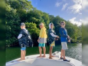 A group of kids enjoys a fishing trip on a boat, showcasing the excitement of outdoor adventures on the water.
