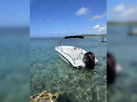 A sleek speedboat anchored in crystal-clear waters, showcasing the beauty of a tropical destination.