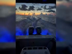 A stunning sunset view from the back of a boat, showcasing the tranquil waters and vibrant sky — perfect for evening cruises and scenic adventures.
